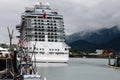 a hugh cruise liner with thousands of holiday makers and hundreds of cabins in the harbour of Juneau