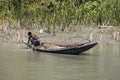 Hularhat, Bangladesh, February 27 2017: Fisherman checks his fishing net for a successful catch in his wooden boat Royalty Free Stock Photo