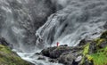 A Huldra seductive forest creature dances in front of the Kjosfossen waterfalls near to flam, Norway