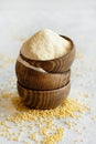 Hulled millet flour in wooden bowls and grain