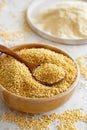 Hulled millet grain and flour in bowls