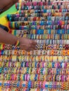 Human arm in front of a display of fabric bracelets