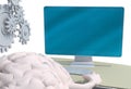 Human brain with arms and legs on the desk in front of the computer