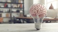 Human brain glowing inside light bulb on desk in office, brainstorming and creative idea Royalty Free Stock Photo