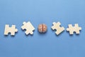 Human brain with a puzzle on blue background. Business idea, memory loss, training and new skills Royalty Free Stock Photo