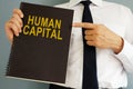 Human Capital concept. Manager holding book.