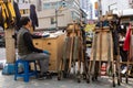 Human carrier at a Korean market. He waits for a call in order to transport items from one place to the other using a wooden