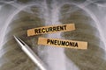 On a human chest x-ray, a pen and strips of paper labeled - recurrent pneumonia