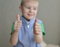 Human child hand gesturing thumb up success sign