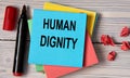 HUMAN DIGNITY - words on a note sheet on a wooden light background Royalty Free Stock Photo