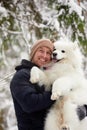 A human and a dog are best friends. Man and dog walk in snowy forest in winter in deep snow on a sunny day. Royalty Free Stock Photo