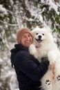 A human and a dog are best friends. Man and dog walk in snowy forest in winter in deep snow on a sunny day. Royalty Free Stock Photo