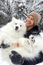 A human and a dog are best friends. Man and dog walk in snowy forest in winter in deep snow on a sunny day. Royalty Free Stock Photo