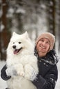 A human and a dog are best friends. Man and dog walk in snowy forest in winter in deep snow on a sunny day. Royalty Free Stock Photo
