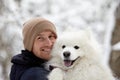 A human and a dog are best friends. Man and dog walk in snowy forest in winter in deep snow on a sunny day. Royalty Free Stock Photo