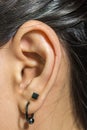 Human ear closeup with metal earring Royalty Free Stock Photo