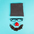 Human face made with a wool hat, glasses, red heart and coffee beans as a beard, funny minimalist portrait, eco freak lifestyle