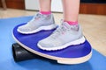 Human feet in jogging shoes standing on balance board Royalty Free Stock Photo