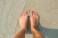 Human feet on sand with a starfish