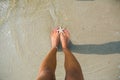 Human feet on sand with a starfish