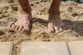 human feet tamping down the sand bed for pavers