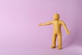 Human figure with arms wide open made of yellow plasticine on violet background. Space for text Royalty Free Stock Photo