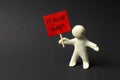 Human figure made of white plasticine holding sign with words Hybrid War on black background Royalty Free Stock Photo