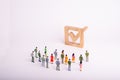 Human figures stand together next to a tick in the box. The concept of elections and social technologies. Volunteers, parties, can Royalty Free Stock Photo