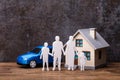 Human Figures Standing In Front Of House And Blue Car