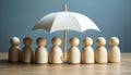 Human figures under umbrella on light wooden table. Insurance concept Royalty Free Stock Photo