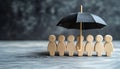 Human figures under umbrella on light wooden table. Insurance concept Royalty Free Stock Photo