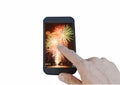 Human finger pointing mobile phone screen with fireworks on white background