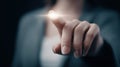 Human finger touching glowing virtual button on dark background futuristic interface technology and digital innovation interaction Royalty Free Stock Photo