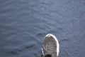 Human foot stepping forward above dark water surface representing risk mistake failure and wrong decision concept in uncertain Royalty Free Stock Photo