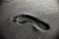 Human footprint on black sand in Tongaporutu, New Zealand. Royalty Free Stock Photo