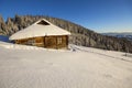 Human footprint path in white deep snow leading to small old wooden forsaken shepherd hut in mountain valley, spruce forest, woody Royalty Free Stock Photo