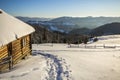 Human footprint path in white deep snow leading to small old wooden forsaken shepherd hut in mountain valley, spruce forest, woody Royalty Free Stock Photo