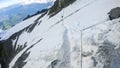 Human footprints on a Couloir passage ridge of Alps snowy mountains