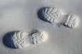 Human footprints boots reflected on the white snow in winter