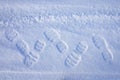 Human footprints and shoe tread marks visible on fresh snow winter surface outdoors Royalty Free Stock Photo