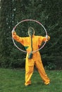 human in a gas mask and a protective yellow suit holding a hula hoop
