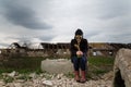 Human in gas mask standing among ruins and dramatic sky background. Enviromental pollution, ecology disaster, radiation Royalty Free Stock Photo