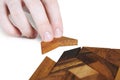 Human hand assembling wooden square puzzle