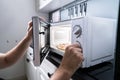 Hand Baking Pizza In Microwave Oven Royalty Free Stock Photo