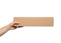 Hand holding a long rectangular cardboard box against a clean white background for delivery or gift purposes Royalty Free Stock Photo