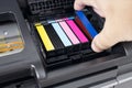 Human hand changing a blue ink cartridge of a inkjet printer Royalty Free Stock Photo