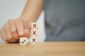 Human hand choose correct sign on wood cube from experience for business, make a decision concept