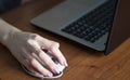 Human hand on computer mouse. Laptop on desk. Royalty Free Stock Photo