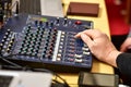 Human hand controls music mixer panel