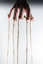 The human hand controls the puppet with the fingers attached to them threads Royalty Free Stock Photo